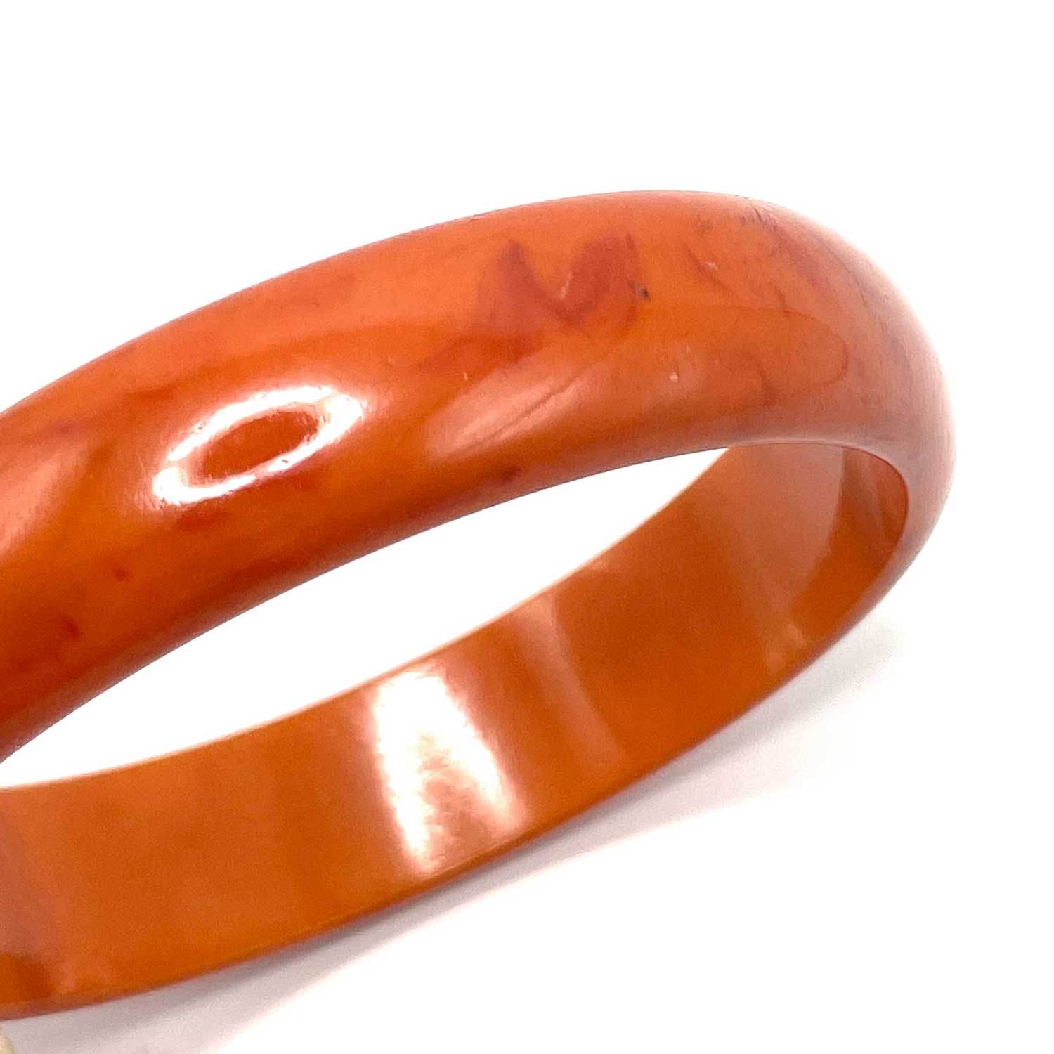 Carved orange swirl bakelite bangle